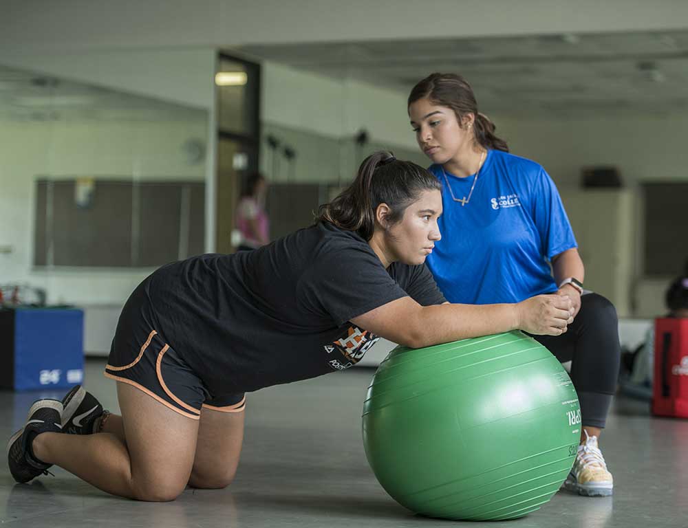 Personal Trainer with patient using exercise ball